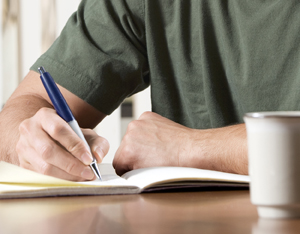 Man writing in a journal. 