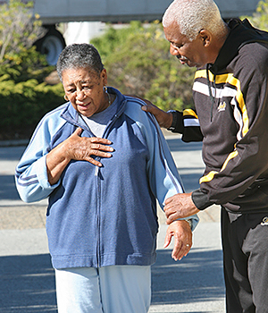 Woman holding hand on chest, looking distressed.