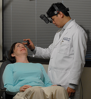 Healthcare provider examining woman's eyes.