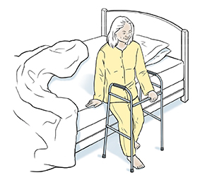 Person sitting at edge of bed with walker.