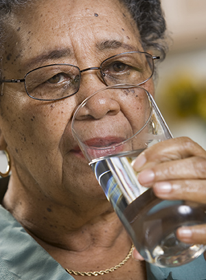 Woman drinking water from a glass.